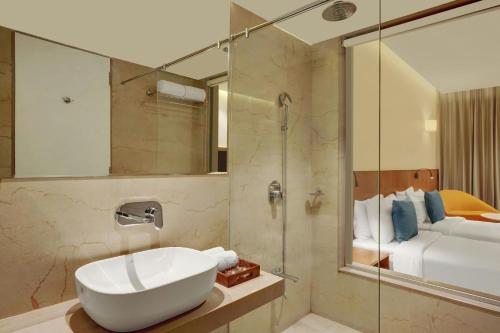 a bathroom with a white sink and a shower at The Fern Residency, Jamnagar, Series by Marriott in Jamnagar
