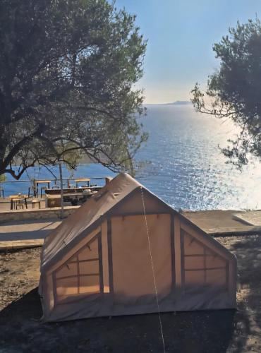 a tent sitting next to a body of water at Cimarte The Path Lukove in Lukovë