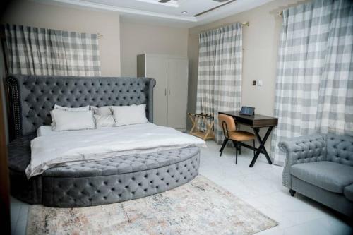 a bedroom with a bed and a desk and a chair at Royal Galaxy Hotel in Kumasi
