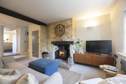 een woonkamer met open haard en tv bij Charming Cotswold Cottage in Central Winchcombe in Winchcombe