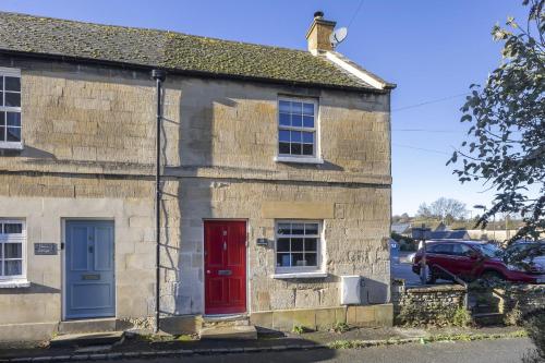een oud stenen huis met een rood-blauwe deur bij Charming Cotswold Cottage in Central Winchcombe in Winchcombe