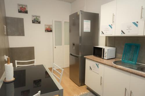 a kitchen with a stainless steel refrigerator and a microwave at Afternoon Desire in Ponta Delgada