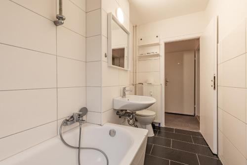 MK Apartments Delmenhorst nähe Bremen 1 في دلمنهورست: حمام مع حوض وحوض استحمام ومرحاض