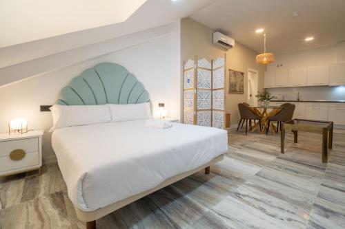 Un dormitorio con una cama grande y una cocina. en William Martin Apartments, en Huelva