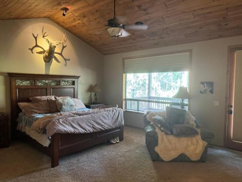 a bedroom with a bed and a chair and a window at Torreon Getaway on the Greens with hot tub, 4 bedrooms, sleeps 10 in Show Low