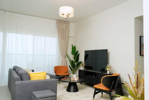 a living room with a couch and a tv at 2BR Apartment In Dubai in JVC near Circle mall in Dubai