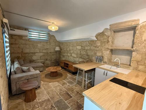 a kitchen and living room with a couch and a table at 'I Elea' Village House with Courtyard in Letimbou
