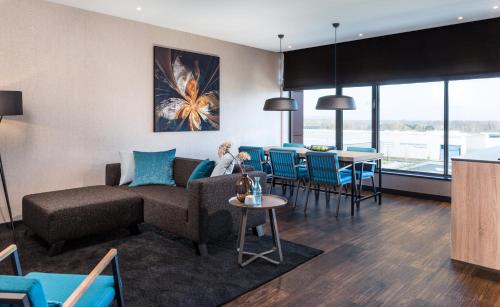 a living room with a couch and a table at Van der Valk hotel Veenendaal in Veenendaal