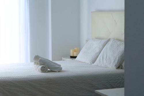 a white bed with a stuffed animal on top of it at Apartamentos Océanos in Málaga