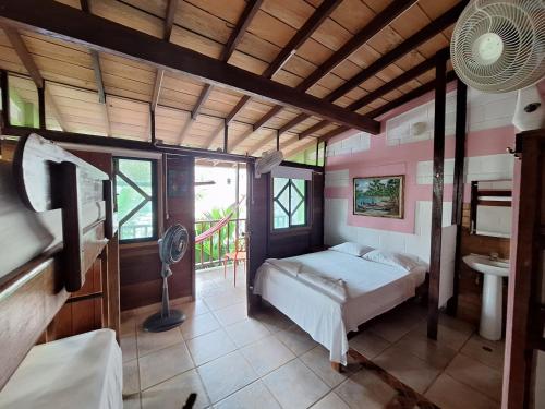 Hostal Capurgana في كابورغانا: غرفة نوم بسرير ومكتب ومروحة