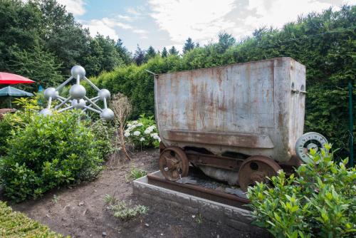 an old rusty train car sitting in a garden at B&B Casa Roman & Vakantiewoning voor 1 pers tot max 32 personen in Zonhoven