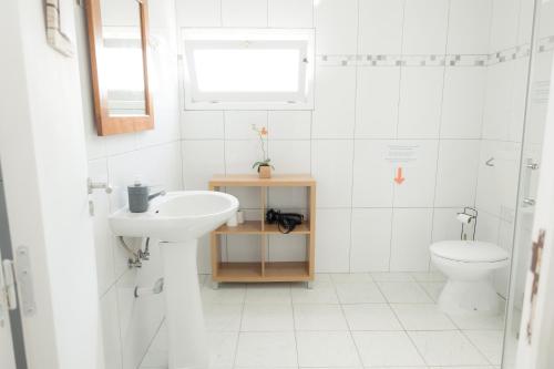 un bagno bianco con lavandino e WC di Afternoon Desire a Ponta Delgada