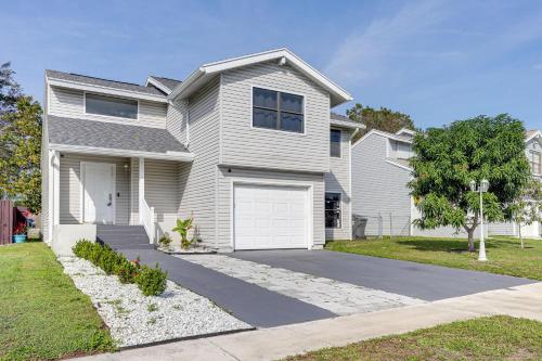 a large white house with a driveway at West Palm Beach Lake House Near Beaches! in West Palm Beach