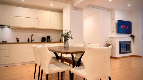 a kitchen and dining room with a wooden table and chairs at Premium Stay - Spacious 3BR with Balcony in Bucharest