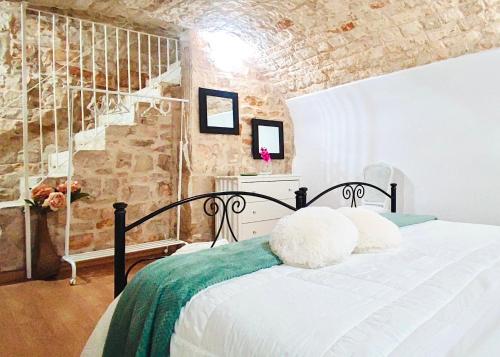 a bedroom with a bed and a brick wall at Gasparro House in Turi