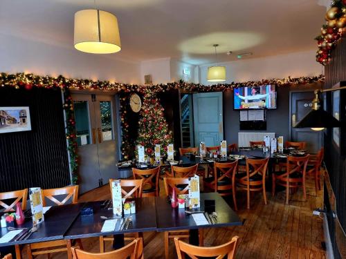 a restaurant with tables and chairs and a christmas tree at The Graeme Hotel in Falkirk