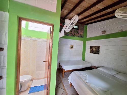 Hostal Capurgana في كابورغانا: حمام به سريران وحوض استحمام ومرحاض