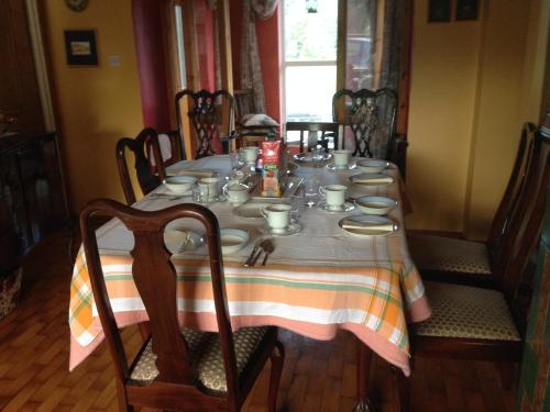 a dining room table with a table cloth and dishes on it at Lisieux House on Lough Neagh in Aghalee