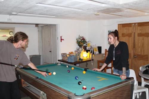two people playing a game of pool in a room at Venice Beach Hostel in Los Angeles