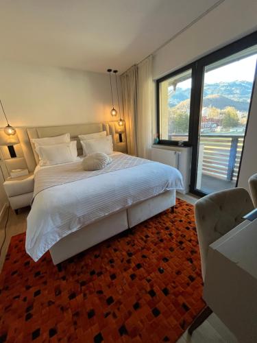a bedroom with a large bed and a large window at Billy&Ane Apartments,Rooms in Sinaia
