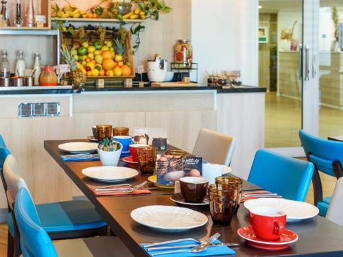 mesa de comedor con sillas azules y cocina en Residhome Toulouse Tolosa, en Toulouse