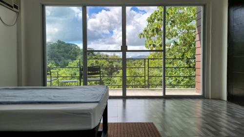 a bedroom with a bed and a large window at Edades Farms in Taysan