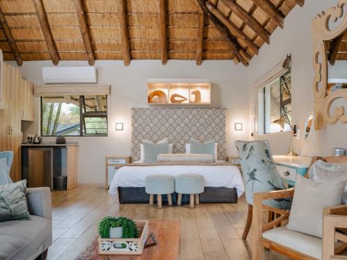 a bedroom with a bed and a living room at La Roca Guest House in Nelspruit