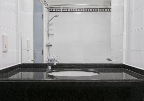 a bathroom with a sink and a shower at Leonardo Hotel East Midlands Airport in Castle Donington