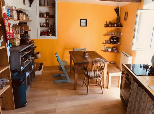 eine Küche mit einem Holztisch und einem Esszimmer in der Unterkunft Chambre au calme in Reillanne