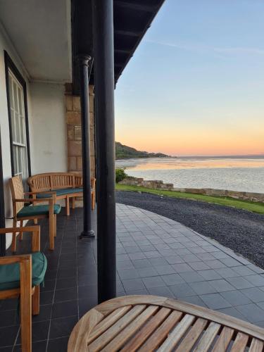 a porch with benches and a view of the ocean at Seaside Cottage, Burntisland, Fife in Burntisland