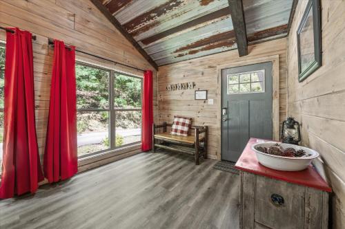a room with red curtains in a wooden cabin at Rustic Retreat — Easy Access, Peaceful Setting, Close to Everything in Sevierville