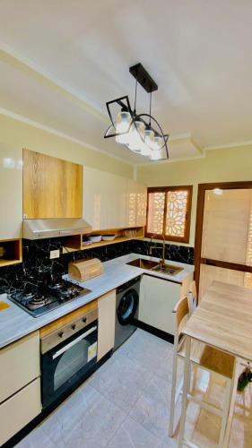 a kitchen with a stove and a table in it at Villa Sabrina in Awlād ‘Umar