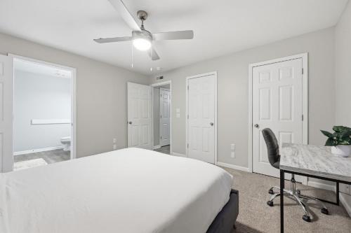 a bedroom with a bed and a desk and a ceiling fan at Trendy 2BR2BA Highland Park Escape in Clarksville
