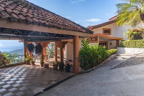 a house with a patio with plants and a roof at Casa Nubes - Ocean View in Carrillo