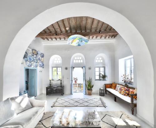 a living room with white walls and an archway at Xinara House in Tripótamos