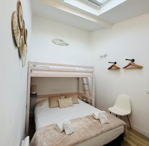 a bedroom with a bunk bed with towels on it at Studio Spa Du Bassin in Le Teich