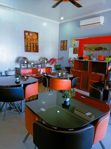 a restaurant with tables and chairs in a room at Hotel Grand illa palopo in Palopo