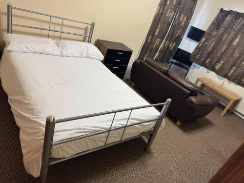 een bed en een stoel in een kamer bij Woodfield Lodge Apartments in Blackpool