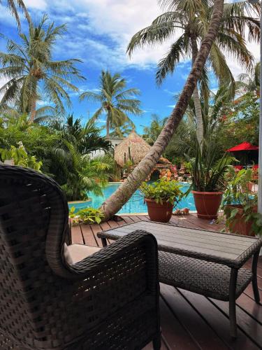 a table and chairs on a deck with a swimming pool at Caye Caulker Boutique Guesthouse 3 in Caye Caulker