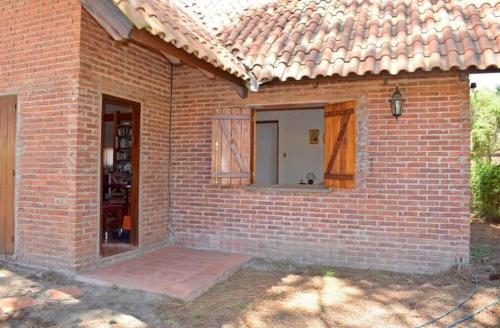 Les Hirondelles BED&BREAKFAST في بيريابوليس: منزل من الطوب مع نافذة وباب