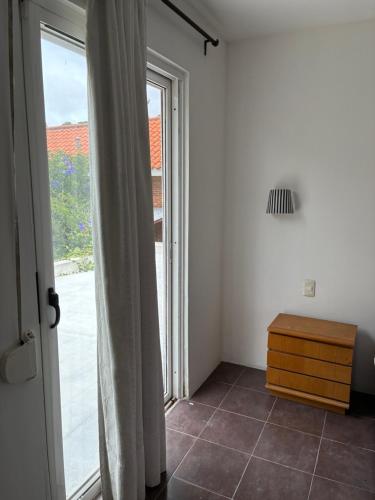 a room with a window and a wooden dresser at La Variopinta in Punta del Este