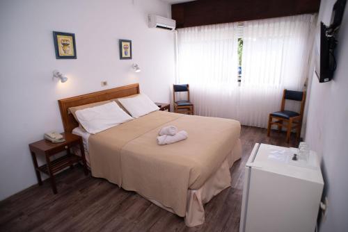 a bedroom with a bed with a towel on it at Hotel Centenario in Atlántida