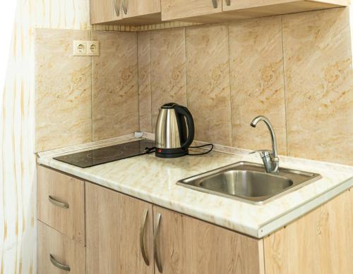 巴统Batumi Inn Hotel的厨房水槽上方配有茶壶