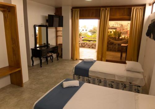 プエルトアヨラにあるAkasha Galápagosのベッドルーム1室(ベッド2台、鏡、ピアノ付)