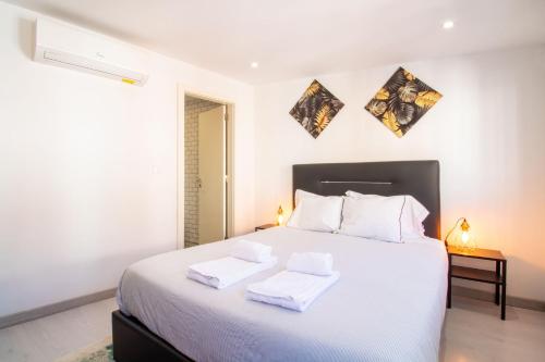 a bedroom with a white bed with two towels on it at Alto da Lapa House w Parking by LovelyStay in Porto
