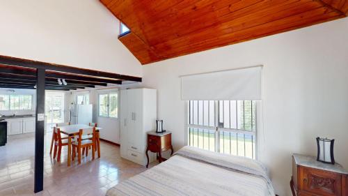 een slaapkamer met een bed en een eetkamer met een tafel bij Casa Tipo Loft- Tigre Centro Con Jardin, Parrilla Y Pileta de Lona Grande 4 Personas in Tigre
