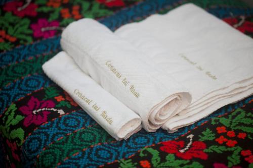 two white towels sitting on top of a blanket at Conacul lui Radu in Făgăraş
