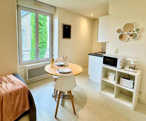 una cucina e un tavolo in una piccola stanza di Résidence du Prieuré a Dinard