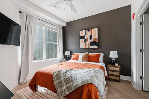 una camera da letto con un letto con lenzuola arancioni e una finestra di Luxury Downtown Property With a Pool a Birmingham