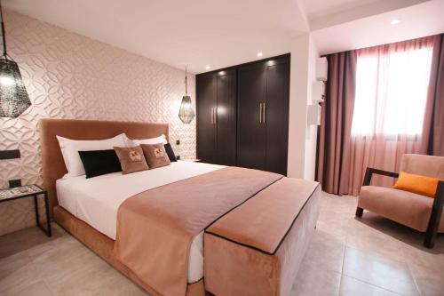 a bedroom with a large bed and a chair at Riad La Petite Majorelle in Marrakesh